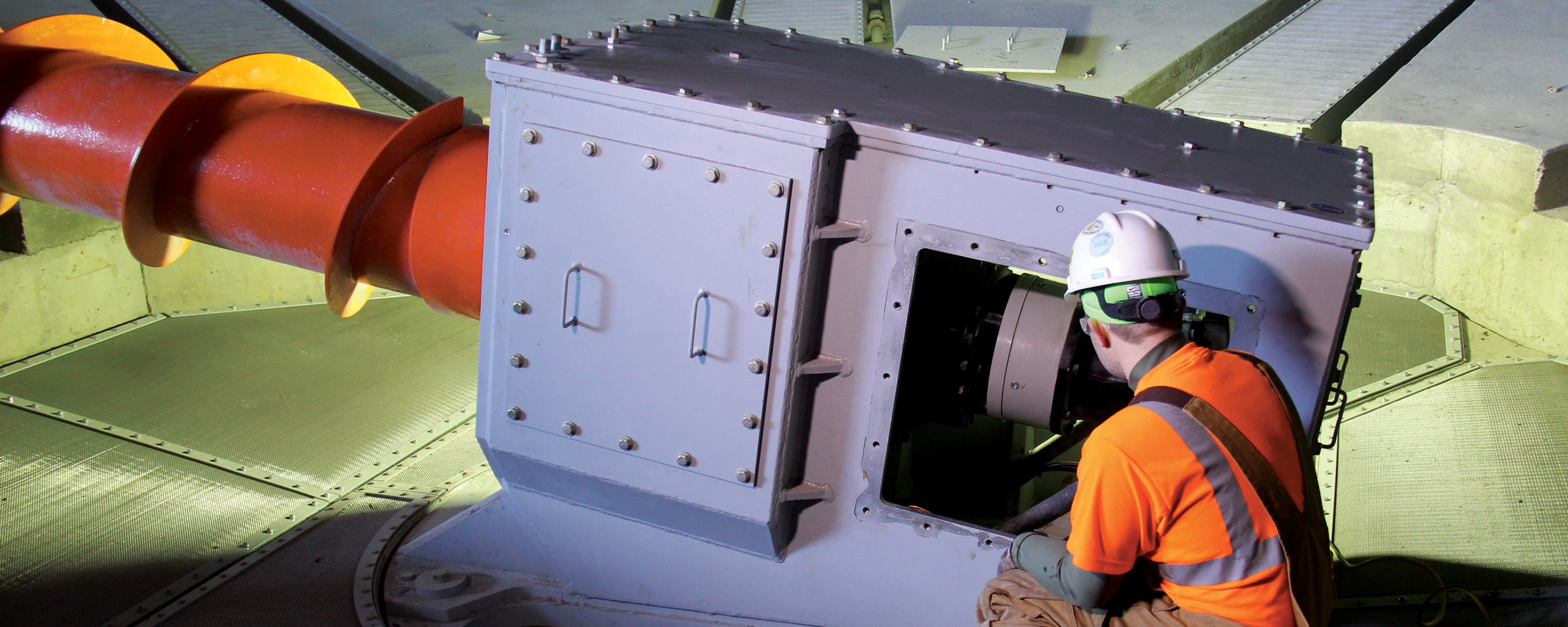 employee inspecting Laidig Fluidized Screw Reclaim System bulk material handling system, bridging, rat-holing, material flow, reclaim, reclaimer, silo unloading, unloader, bulk material storage, reclaim system, dry bulk unloading, grain unloading