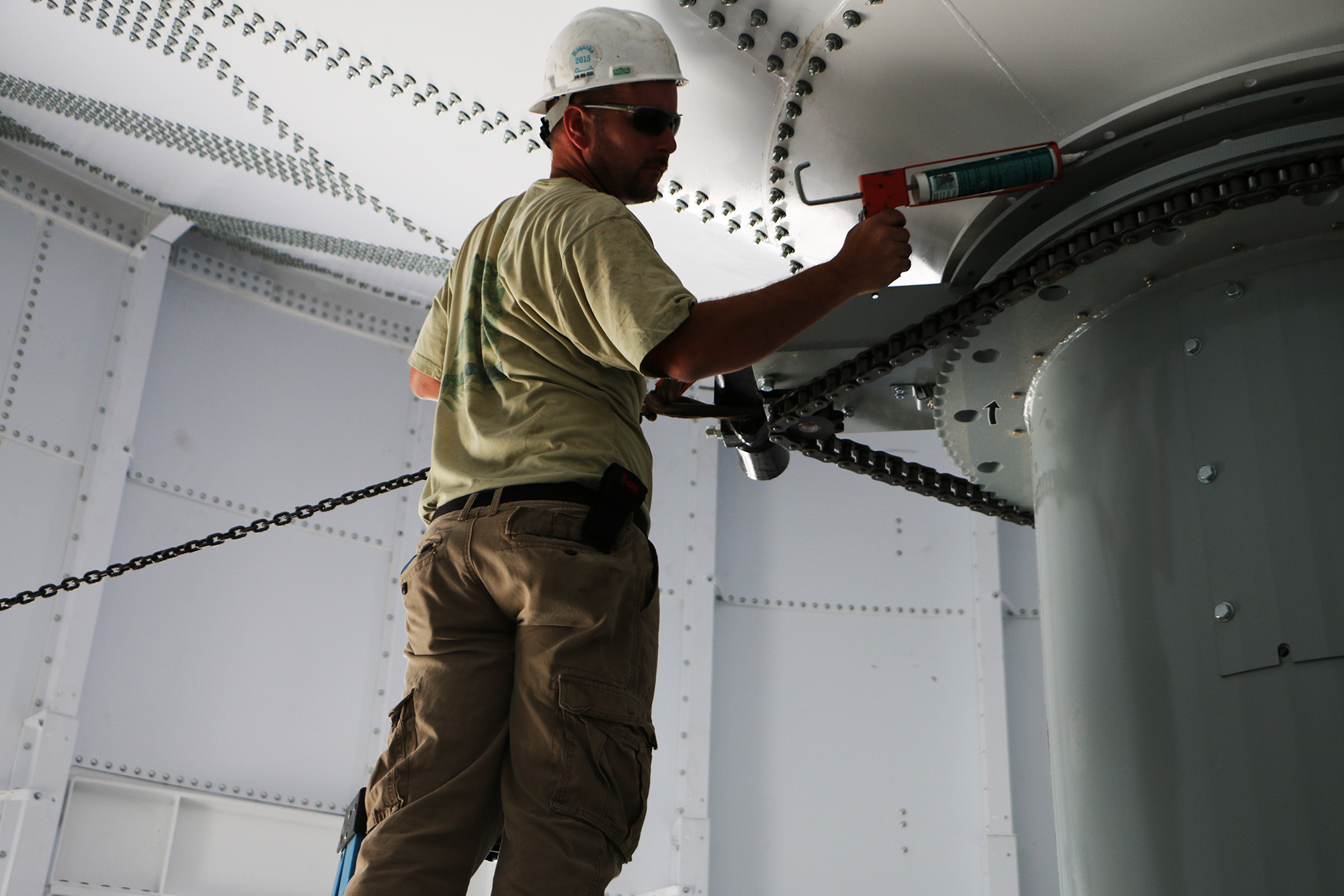 Laidig Field Service Technician finishing up installation on Laidig cone-bottom reclaimer bulk material handling system, bridging, rat-holing, material flow, reclaim, reclaimer, silo unloading, unloader, bulk material storage, reclaim system, dry bulk unloading, grain unloading