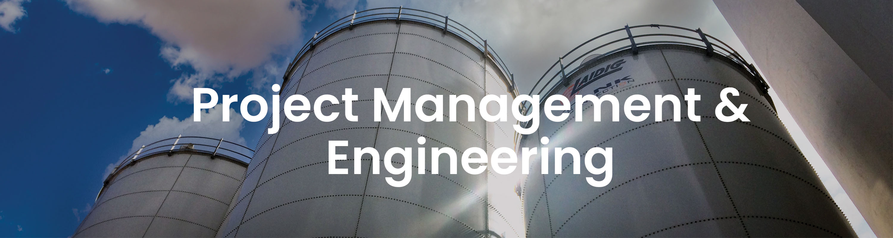 silo background with white text that reads PROJECT MANAGEMENT & ENGINEERING bulk material handling system, bridging, rat-holing, material flow, reclaim, reclaimer, silo unloading, unloader, bulk material storage, reclaim system, dry bulk unloading, grain unloading